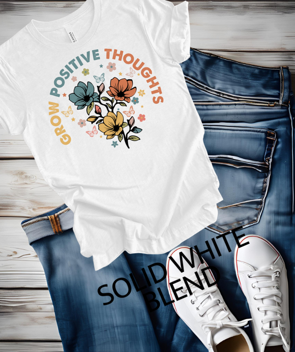 Grow Positive Thoughts Graphic Tee on jeans with sneakers, featuring a colorful floral design.