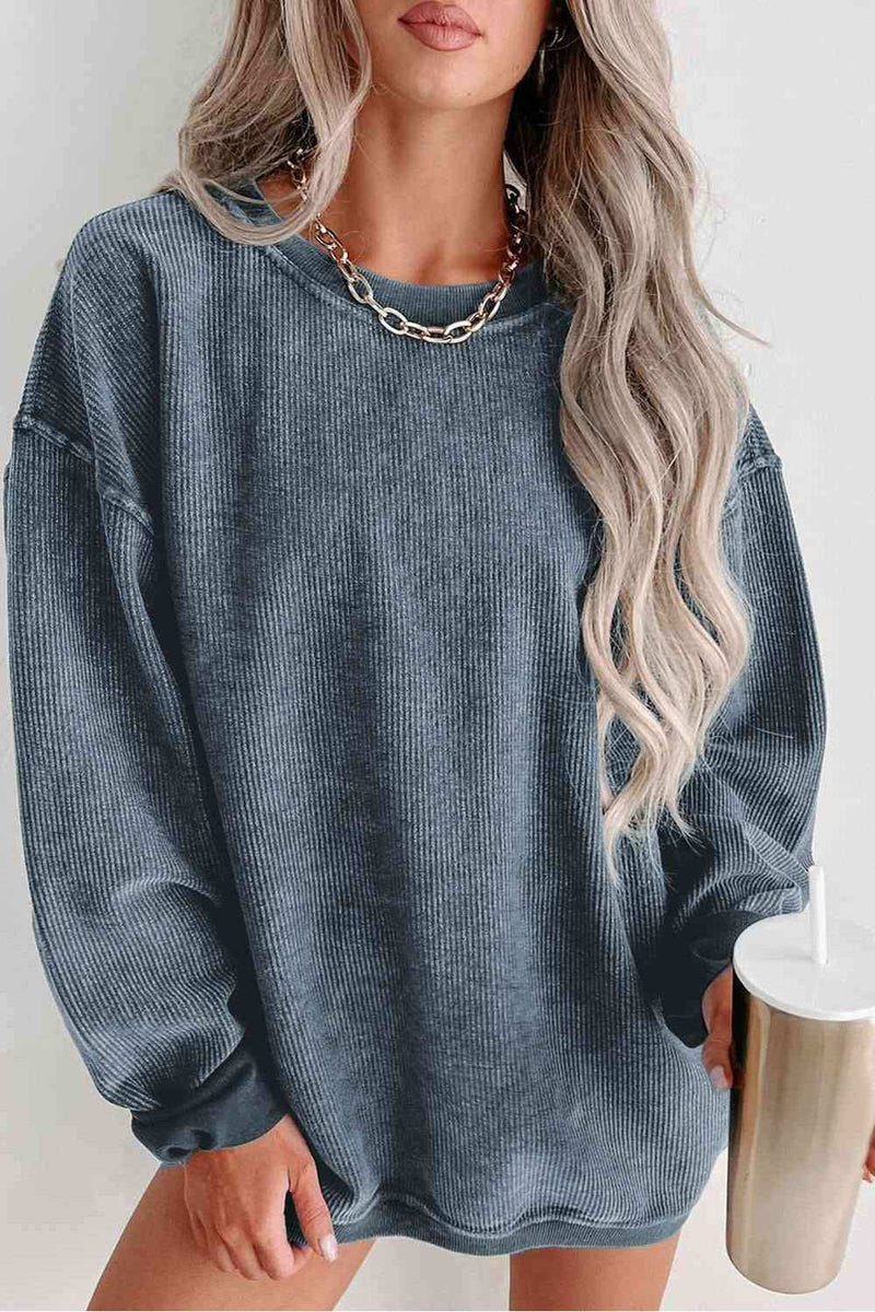 Round Neck Dropped Shoulder Sweatshirt with ribbed cuffs in blue, worn by model.